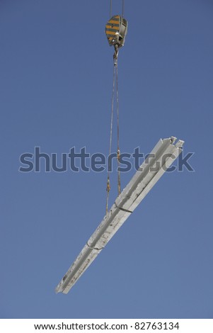 Closeup of construction crane lifting metal bars