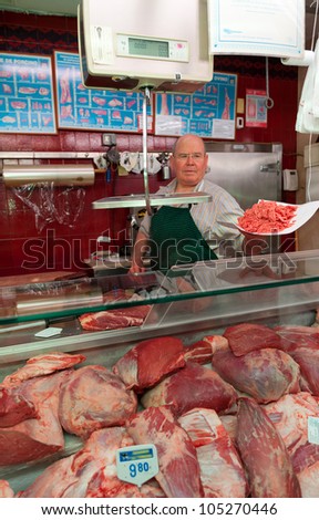 Butcher presenting a wrapping paper with ground beef