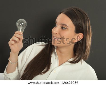 Woman holding a light bulb with a happy expression