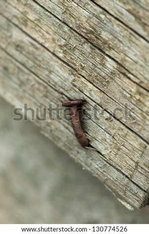 Old weather beaten wooden plank with rusty nail