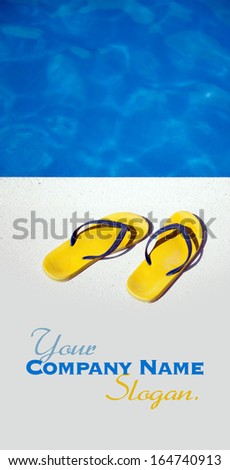A pair of yellow and blue sandals by a swimming pool