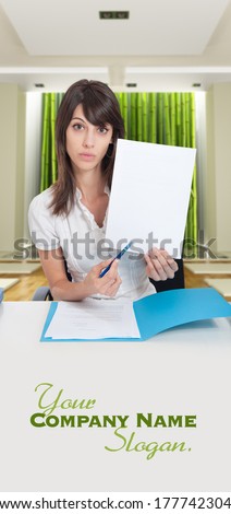 Young woman in zen interior pointing with her pen to a blank paper. Ideal for inserting your own message