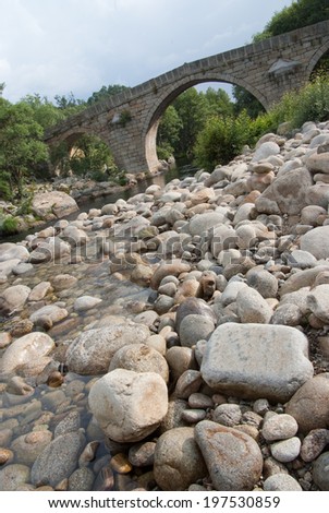 Small river bend and stone bridge