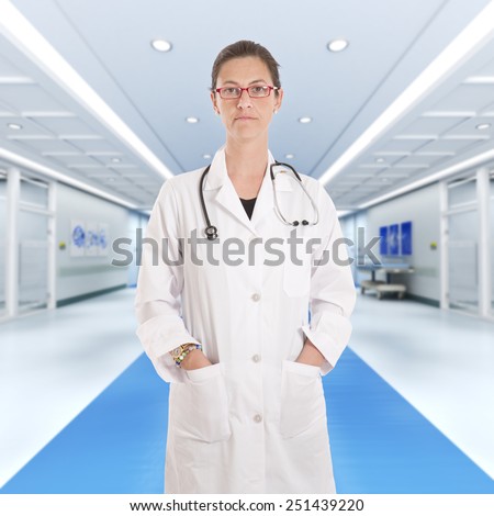 Serious female doctor standing at a hospital corridor