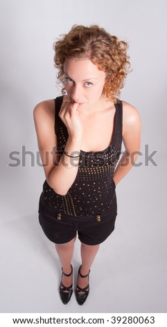 Young blond woman biting her nails with a thoughtful expression