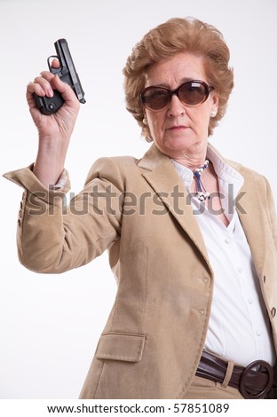 stock photo Mature lady with sunglasses and a gun in her hand