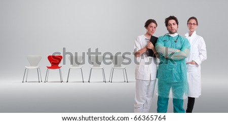 A surgeon and his team with a row of white chairs and a red one