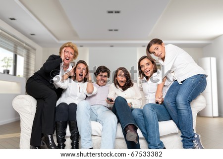 A group of family members sitting at home watching nervously a match