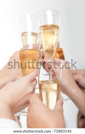 Seven hands raising champagne flutes on a toast