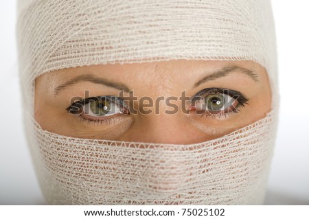 Close-up portrait of a woman with a bandaged head and face