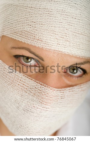Close-up portrait of a woman with a bandaged head and face
