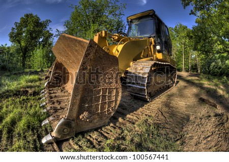 A High Dynamic Range wide angle photo of a bulldozer at a construction site.