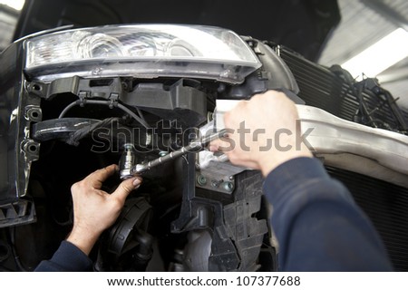 Detailed image of car repair, service and inspection by mechanic in auto garage.