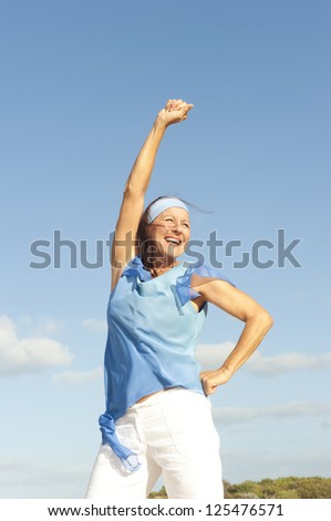 Portrait beautiful looking middle aged woman confident, happy and successful smiling, enjoying active retirement, isolated with blue sky as background and copy space.