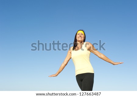 Portrait beautiful mature woman, happy, friendly, relaxed, healthy lifestyle, isolated with blue sky as background and copy space.