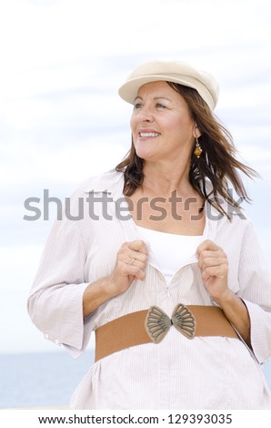 Portrait happy confident attractive mature woman joyful and smiling, isolated outdoor with white bright blurred background.