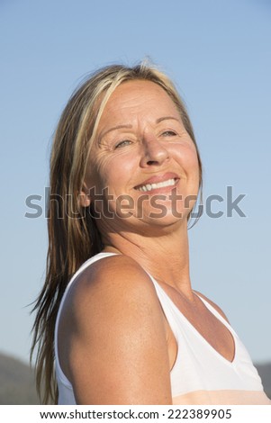 Portrait joyful attractive mature retired woman at sunny day outdoor, happy friendly confident smiling, with blue sky as background and copy space.