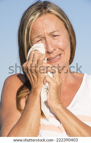Portrait unhappy mature woman, wiping tears from eyes, with sad crying facial expression outdoor.