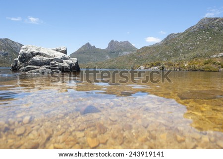 Beautiful landscape of Cradle Mountains National Park in Tasmania, Australia, with mirror image on Dove Lake in foreground and the mountain range in back, blue sky as copy space.