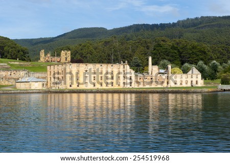 World Heritage Site of former Penal Convict Settlement Port Arthur on Tasmania, Australia, with ruin of prison at water of harbour and other old buildings.