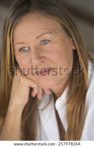 Portrait attractive mature woman with serious sad facial expression, thoughtful, blurred background.