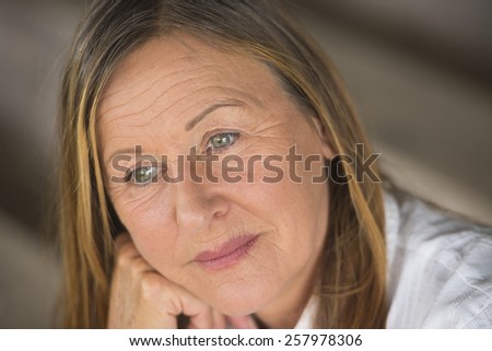 Portrait attractive mature woman with serious happy confident facial expression, thoughtful, blurred background.