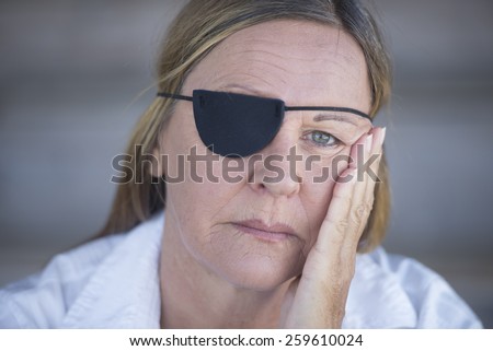 Portrait depressed attractive mature woman wearing eye patch as protection after injury, closed eyes, blurred background.