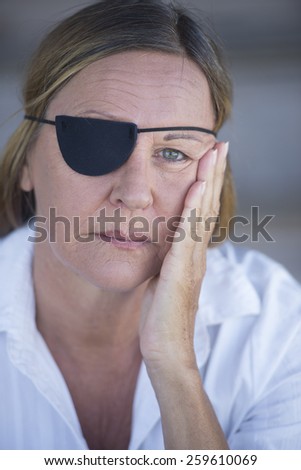 Portrait stressed attractive mature woman wearing eye patch as protection after injury, closed eyes, blurred background.