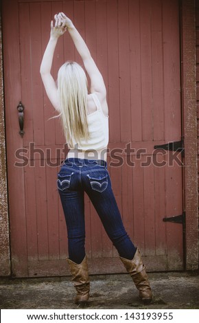 Beautiful girl wearing jeans and white t-shirt posing with her arms up