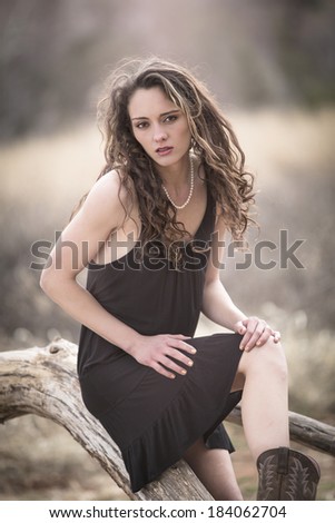 Sassy model posing in a black dress in a Vintage outdoor environment