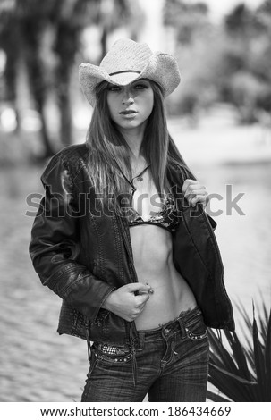 Black and white portrait white lady in cowboy hat and wearing jacket and jeans