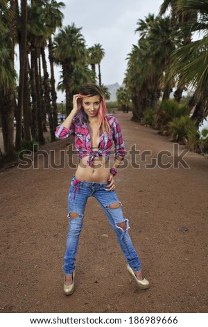Happy girl wearing pink flannel shirt and jeans with high heels