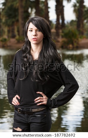 Punk rock young looking lady in jet black hair and black outfit