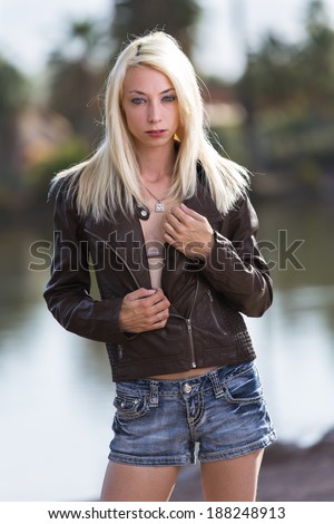 Very skinny model with blonde straight hair posing outdoors