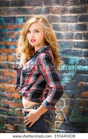 Young blonde girl in strip flannel shirt and shorts