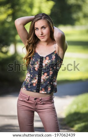 Gorgeous and young model posing in tight low rise pink jeans and blouse