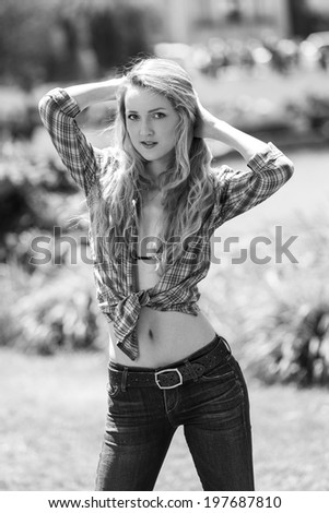 Black and white portrait of a young women posing with arms up