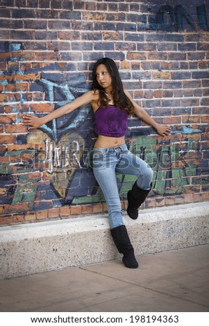 Young mexican female model in jeans and purple shirt