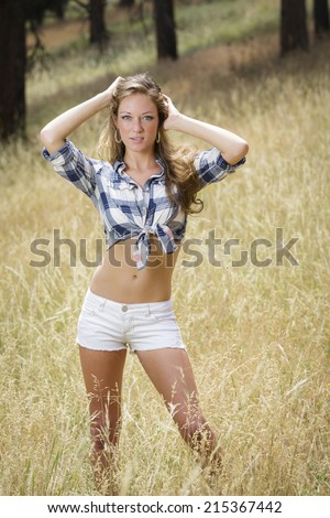 Healthy and young cowgirl wearing flannel shirt and white shorts