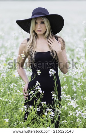 Young female model wearing a black hat and a black dress
