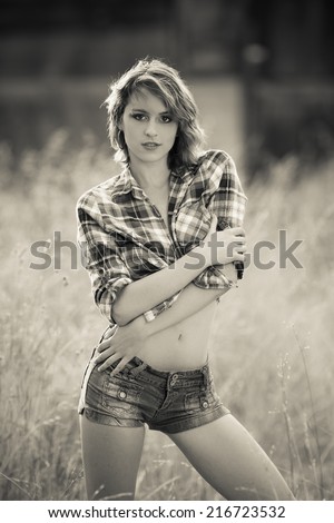Black and white portrait of a young model in western wear in flannels top and jeans shorts