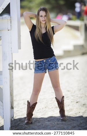 young American girl in denim shorts and cowboy boots