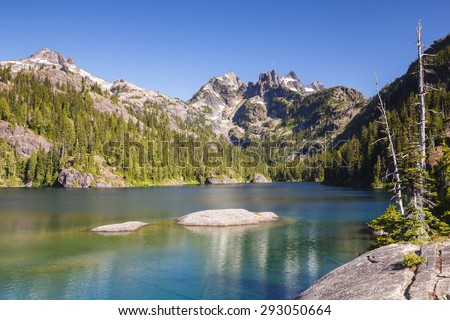 Calm and relaxing landscape of clear and tranquil water with rugged mountain peak