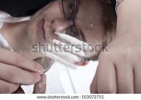 Drug addicted junkie woman reflected in mirror and lines of cocaine.