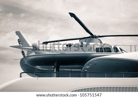 Detail of luxury yacht with helicopter on the deck, digitally retouched and toned photo.