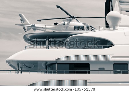 Luxury yacht with helicopter on the deck, digitally retouched and toned photo.