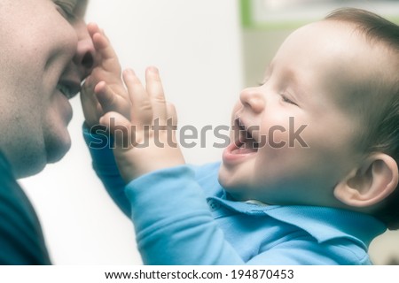 Closeup of happy child boy playing with his daddy.