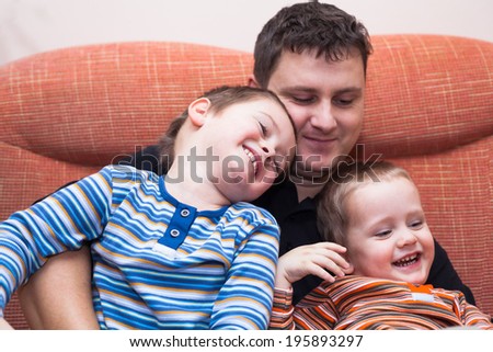 Happy children boys and daddy having fun on sofa at home