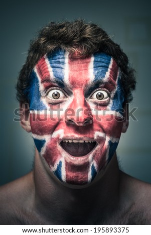 Portrait of shocked man with British flag painted on face.