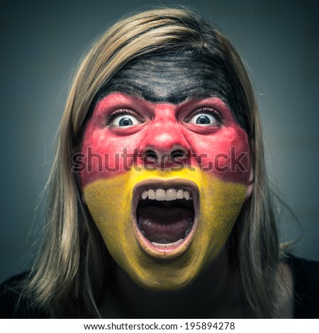 Portrait of angry woman with flag of Germany painted on face.